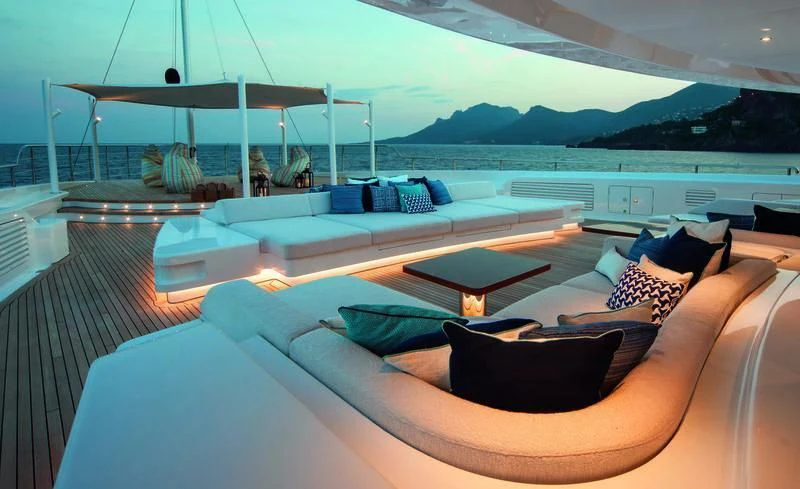 a large lounge area with a large lounge chair and a large body of water aboard STARBURST IV Yacht for Charter