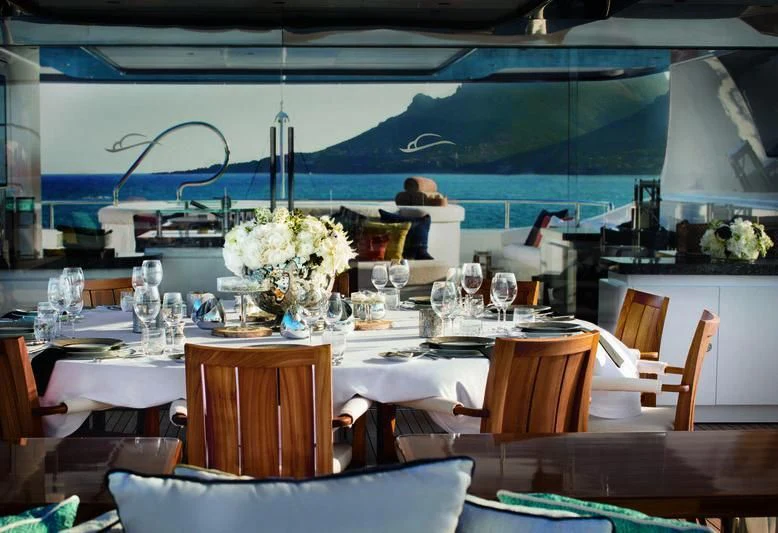 a dining table with a white flower vase and white flowers aboard STARBURST IV Yacht for Charter
