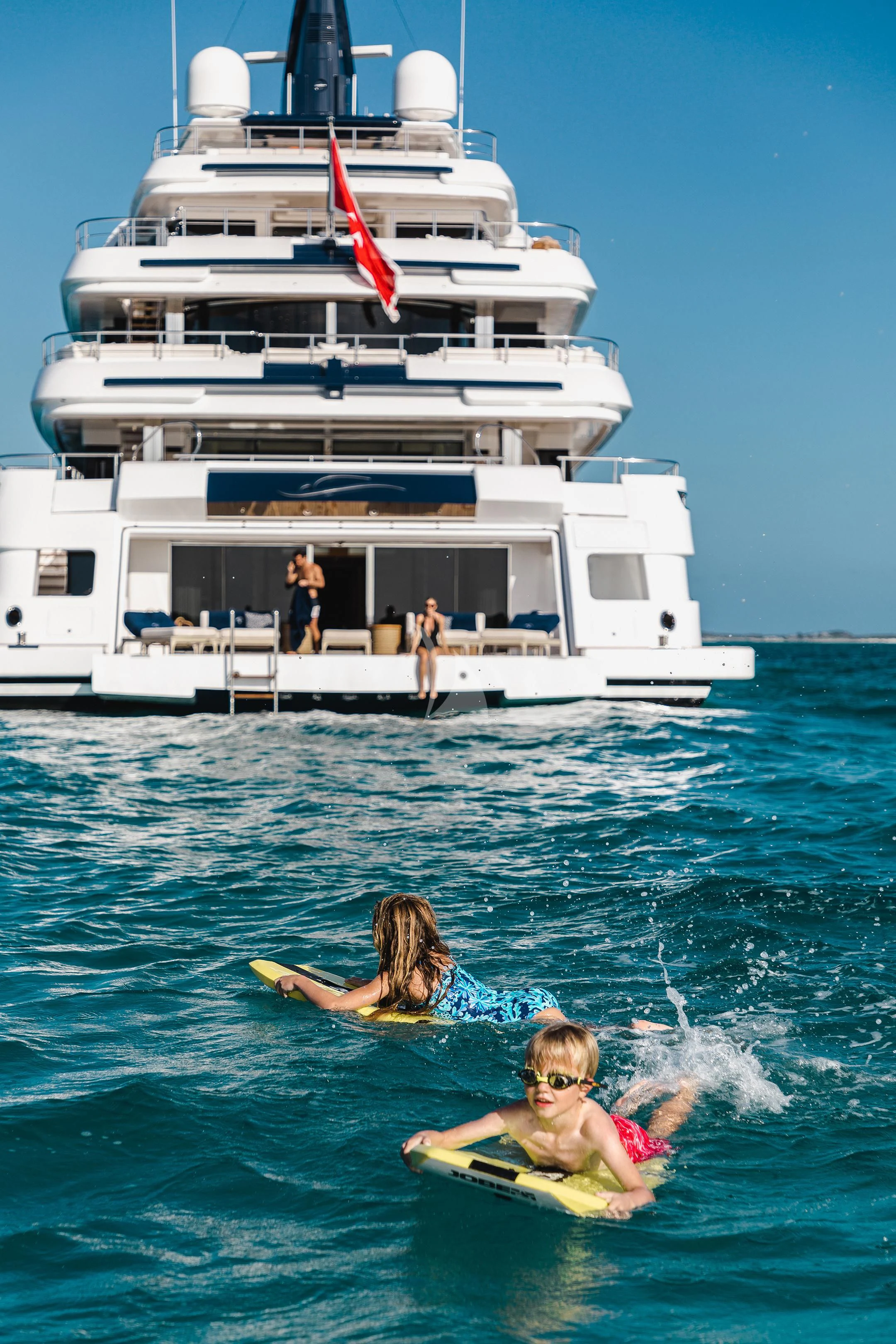 a couple of women in the water in front of a white boat aboard STARBURST IV Yacht for Charter