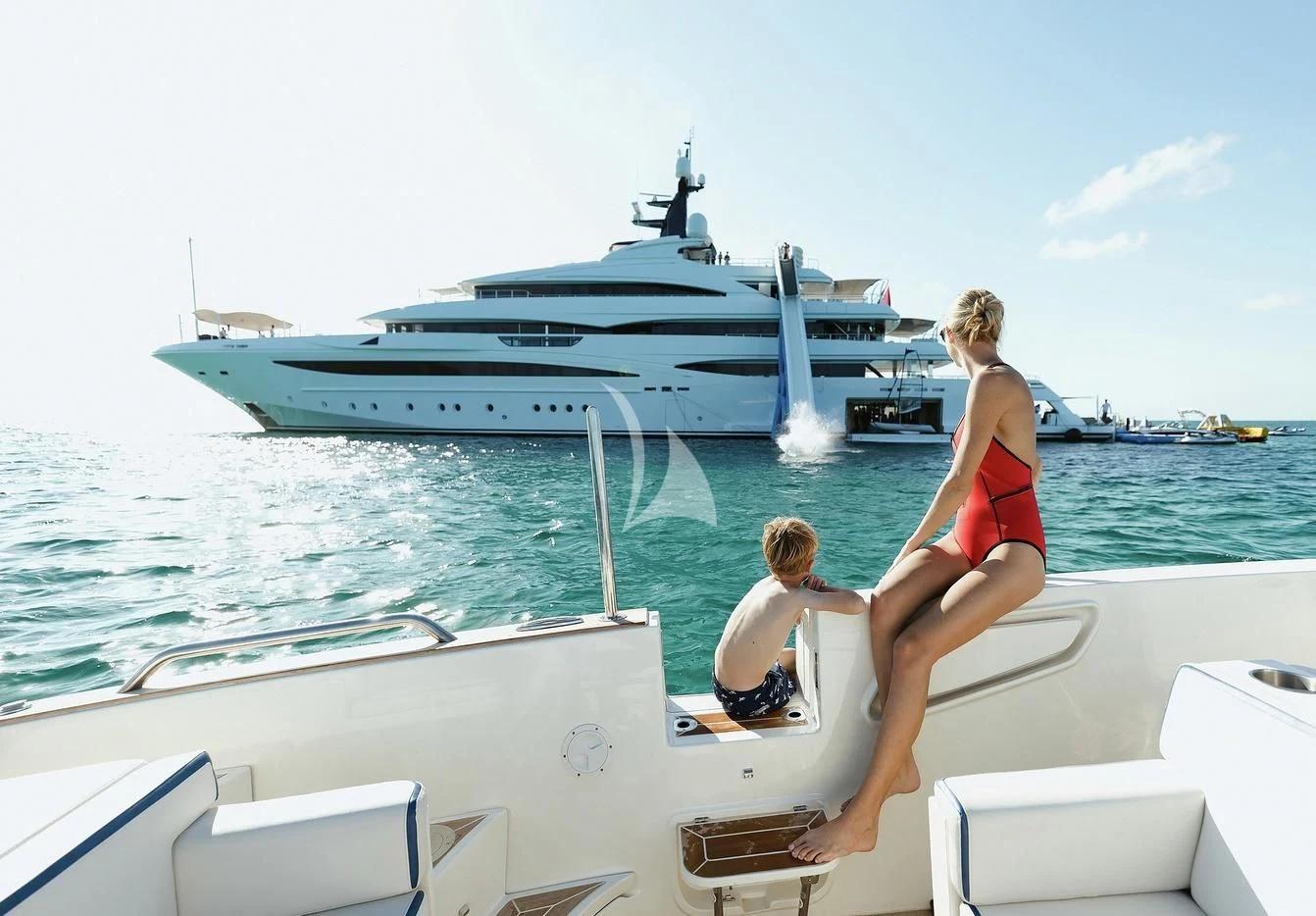 a man and woman sitting on a boat looking at a large ship aboard STARBURST IV Yacht for Charter