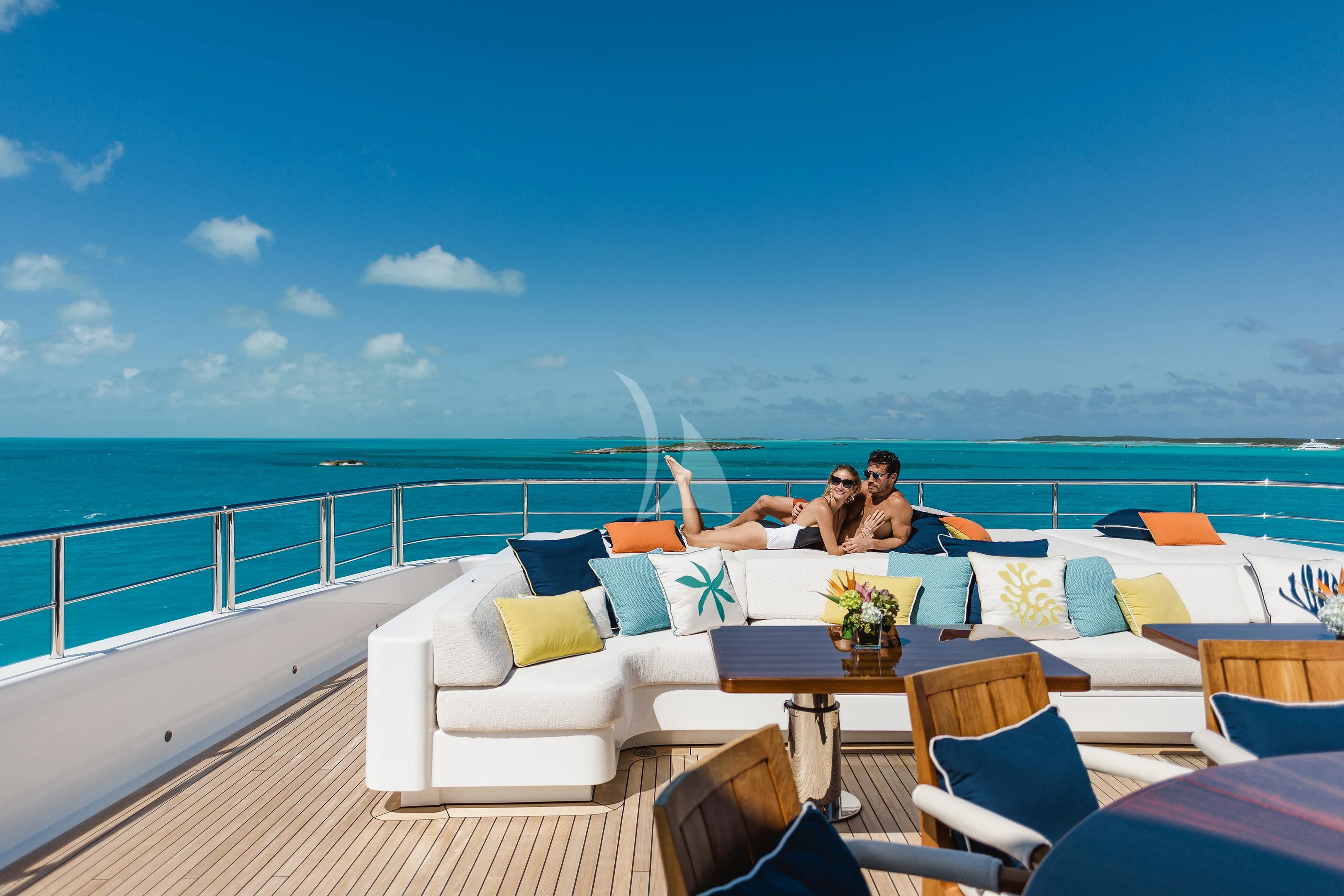 a group of people sitting on a couch on a deck overlooking the ocean aboard STARBURST IV Yacht for Charter
