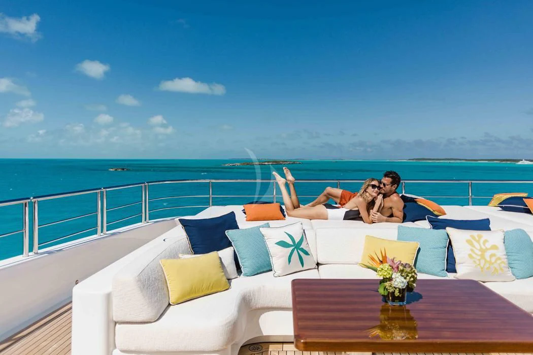 a couple sitting on a couch on a balcony overlooking the ocean aboard STARBURST IV Yacht for Charter
