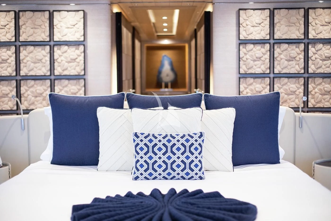 a bed with blue and white pillows aboard STARBURST IV Yacht for Charter