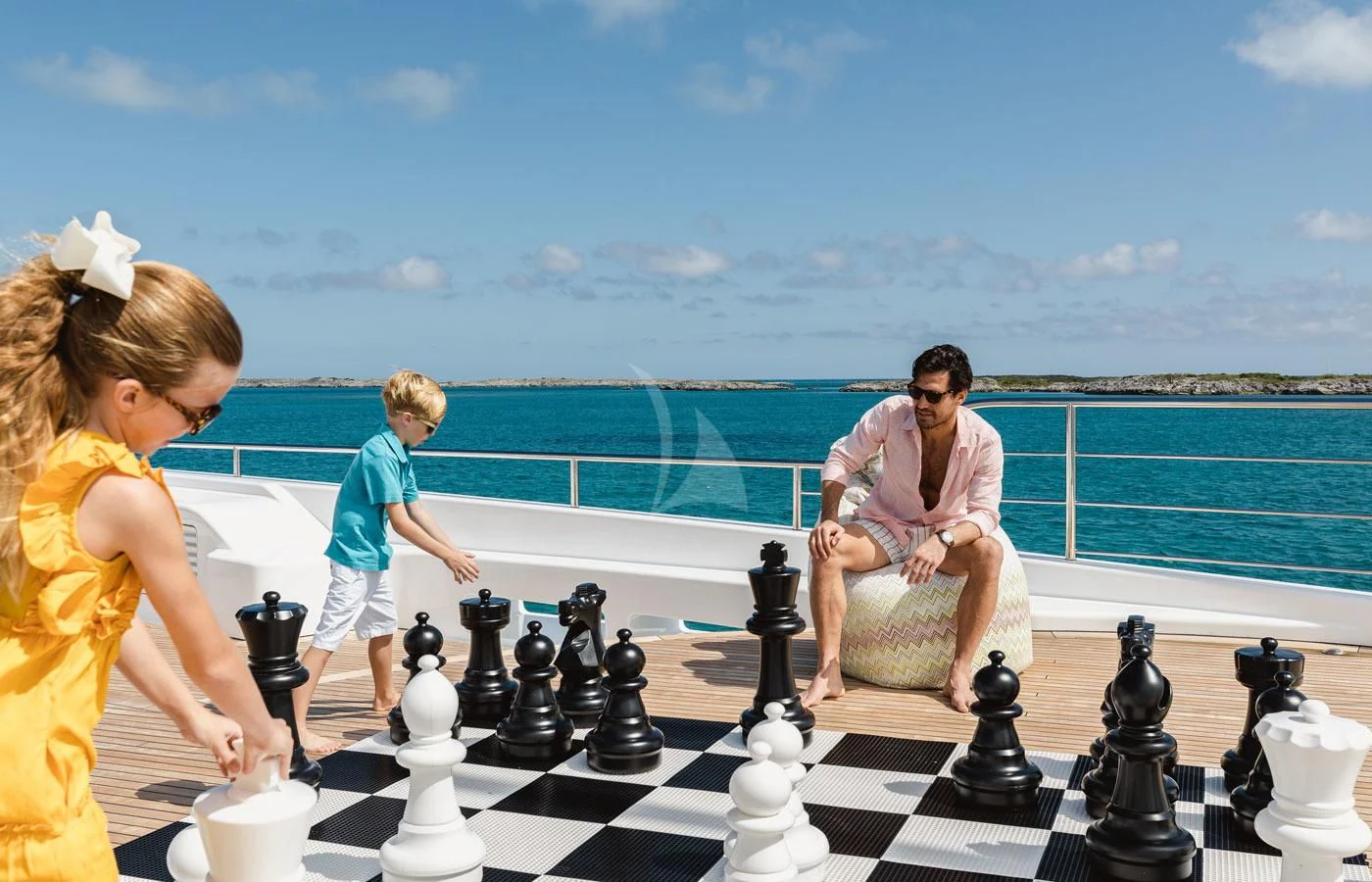 a family playing chess on a deck aboard STARBURST IV Yacht for Charter