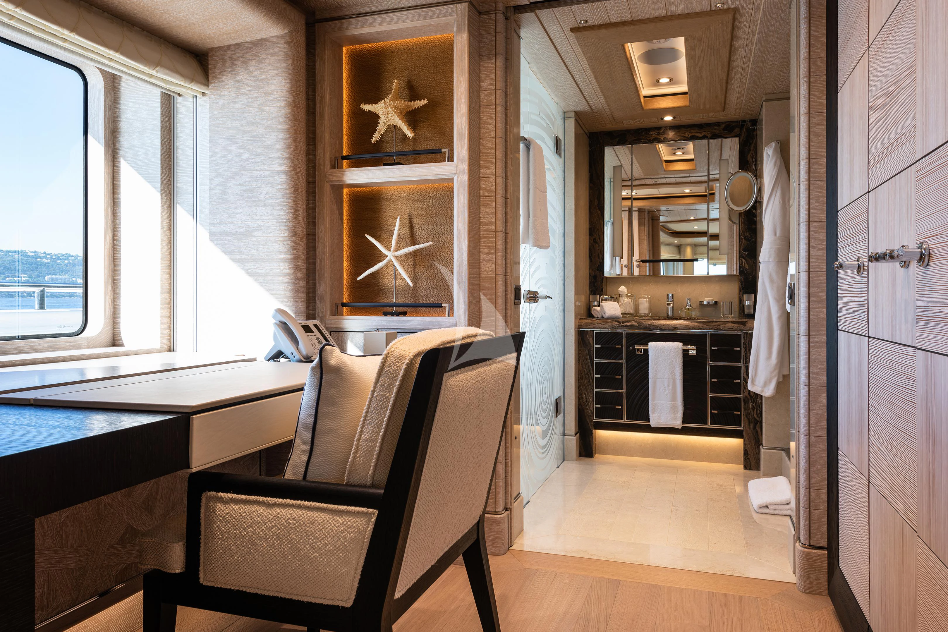 a room with a chair and a table and a window aboard STARBURST IV Yacht for Charter