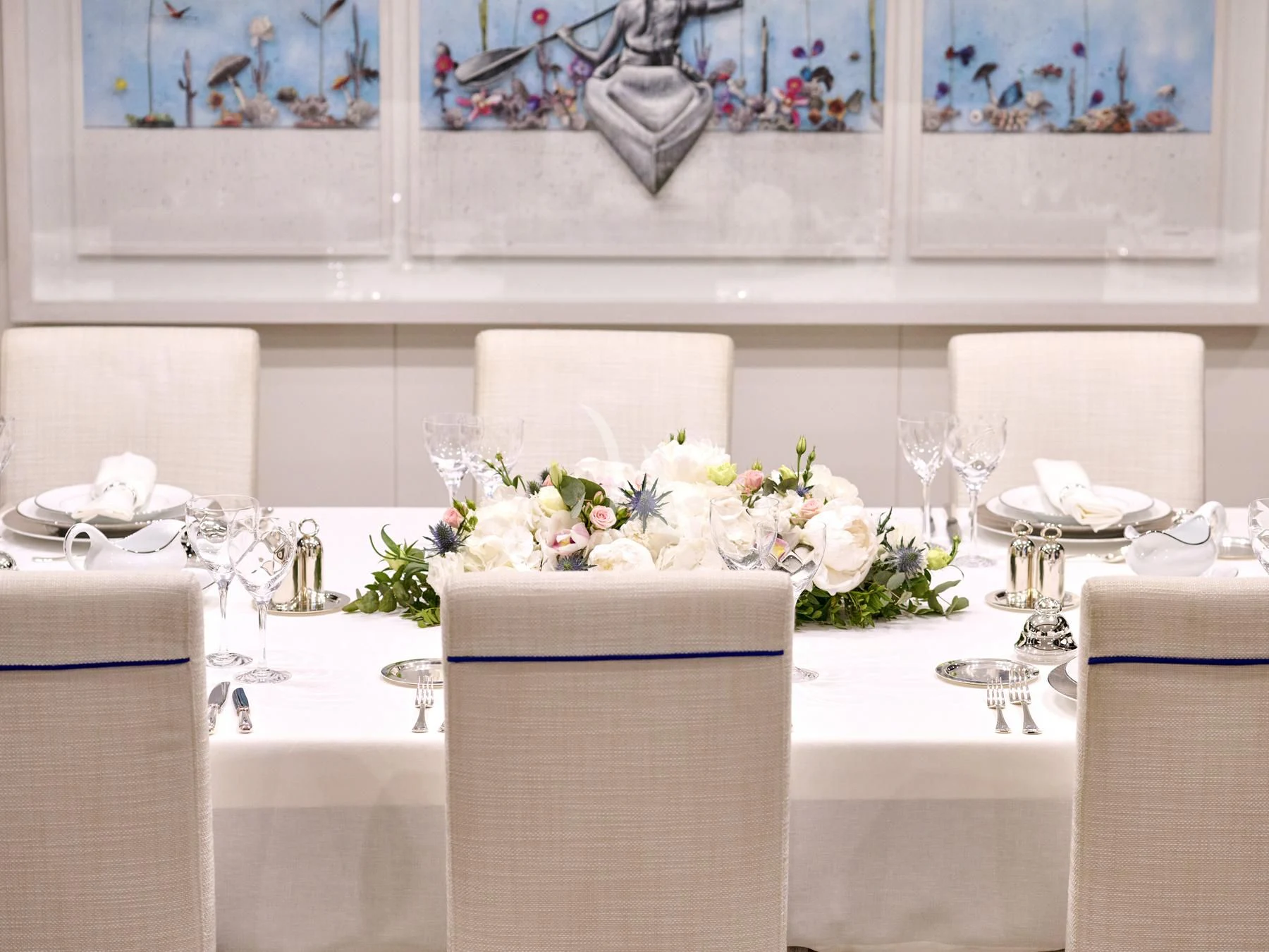 a table with flowers and a picture on the wall aboard HAKUNA MATATA Yacht for Charter