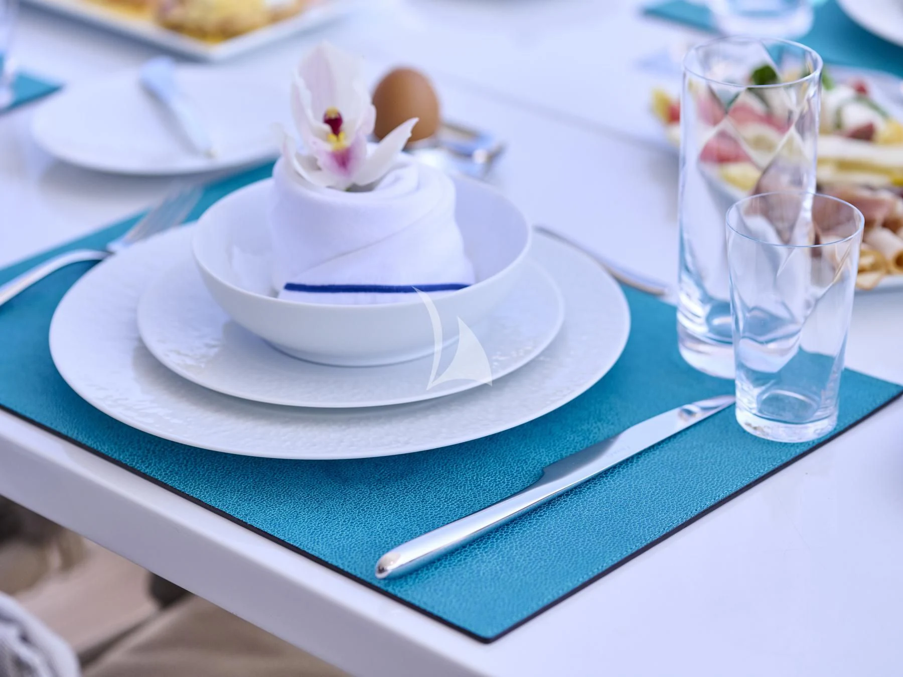 a white plate with a spoon on it aboard HAKUNA MATATA Yacht for Charter