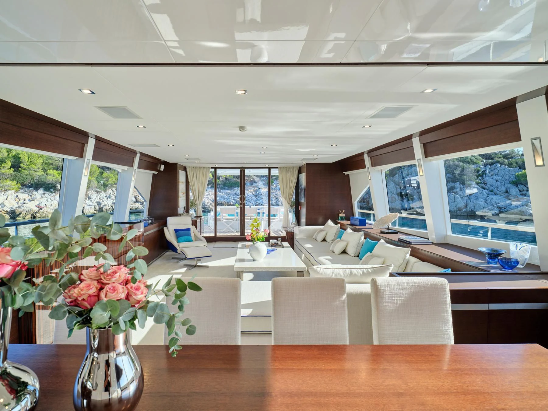 a room with a table chairs and flowers in it aboard HAKUNA MATATA Yacht for Charter