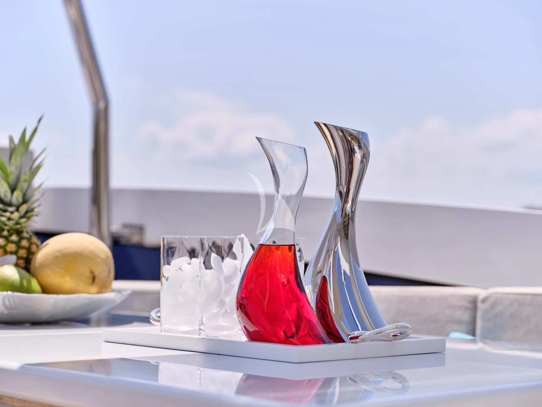 a glass and a fruit on a table aboard HAKUNA MATATA Yacht for Charter
