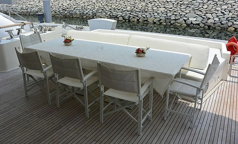 a table and chairs on a patio aboard HAKUNA MATATA Yacht for Charter