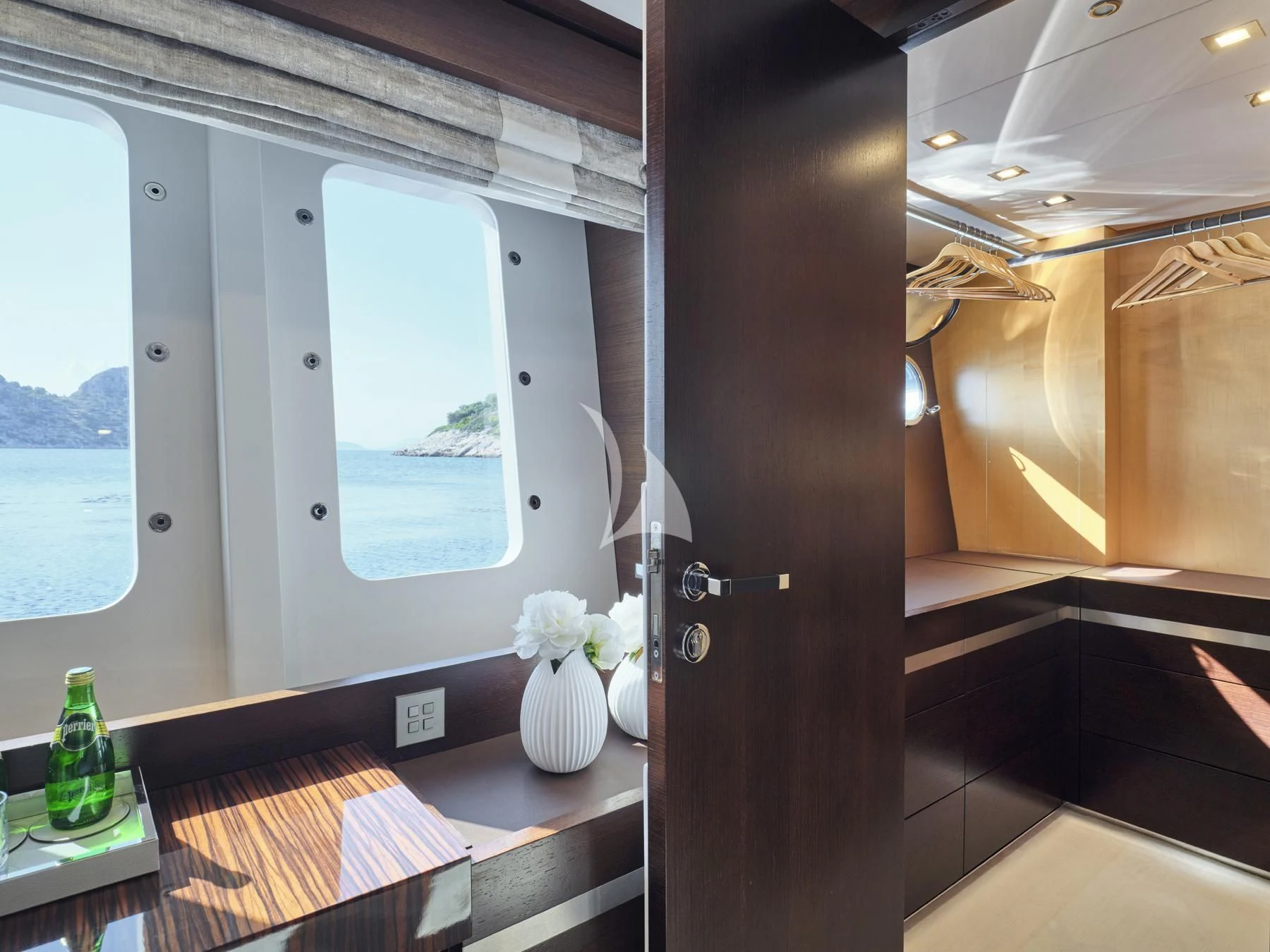 a room with a glass door and a vase with flowers in it aboard HAKUNA MATATA Yacht for Charter