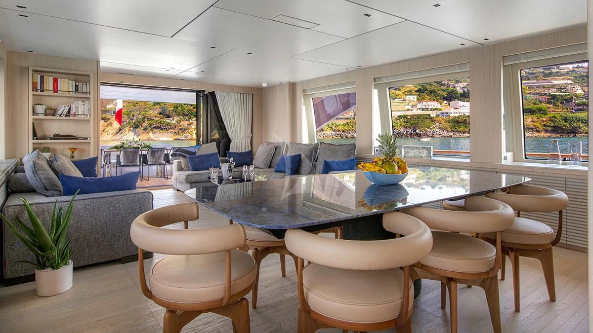 a large living room with a table and chairs aboard ANGIOLA Yacht for Sale