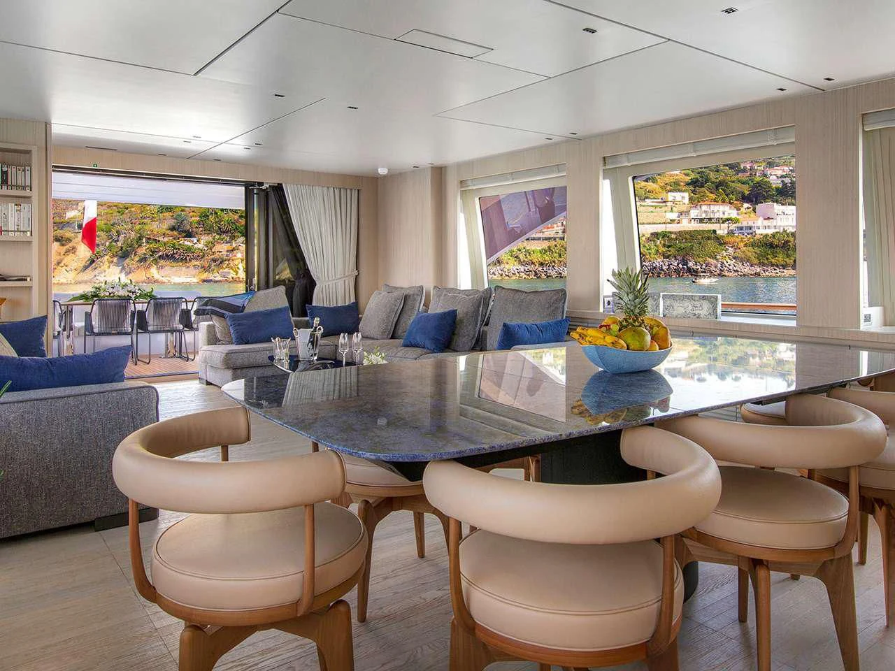a large living room with a large table and chairs aboard ANGIOLA Yacht for Sale