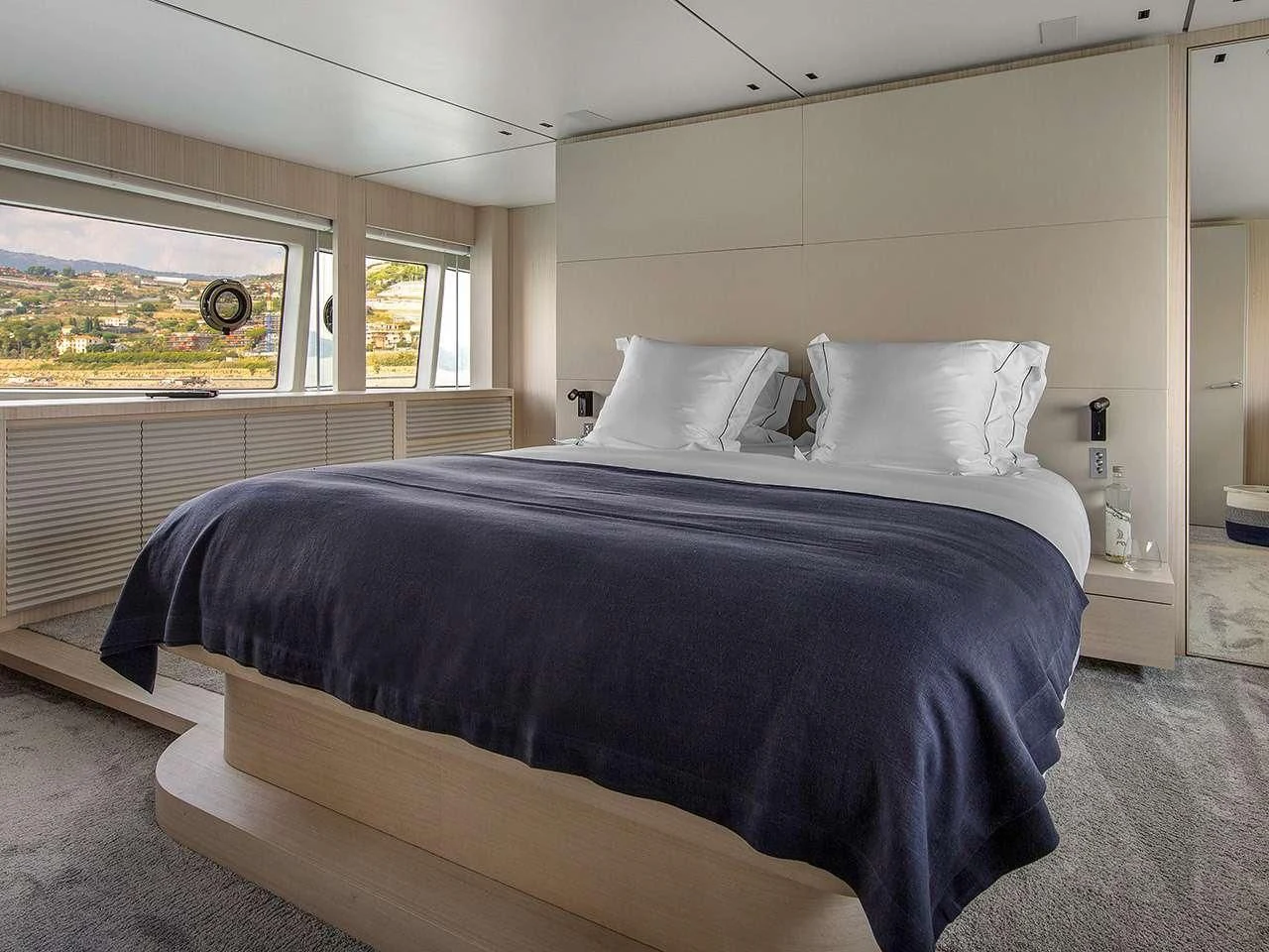 a bedroom with a bed and a window aboard ANGIOLA Yacht for Sale