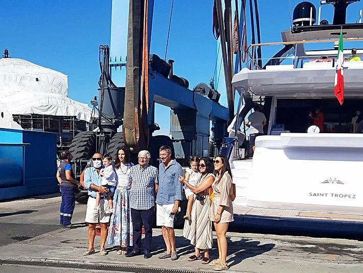 a group of people posing for a photo next to a boat aboard ANGIOLA Yacht for Sale