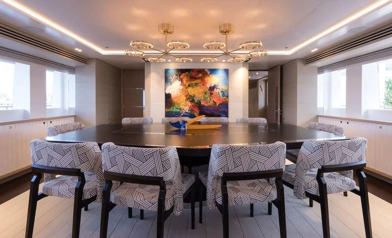 a large dining table with chairs around it aboard ARTISA Yacht for Sale