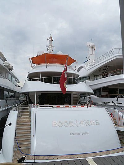 a large white boat with a red flag on it aboard ARTISA Yacht for Sale