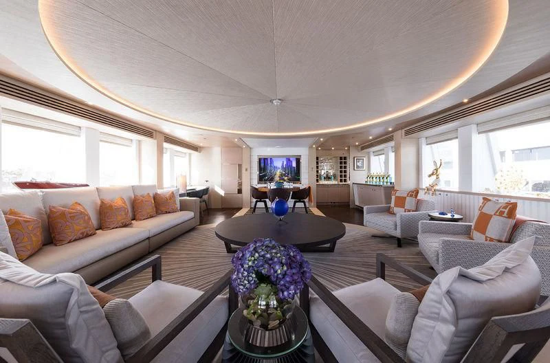 a living room with a large white sofa and a large window aboard ARTISA Yacht for Sale