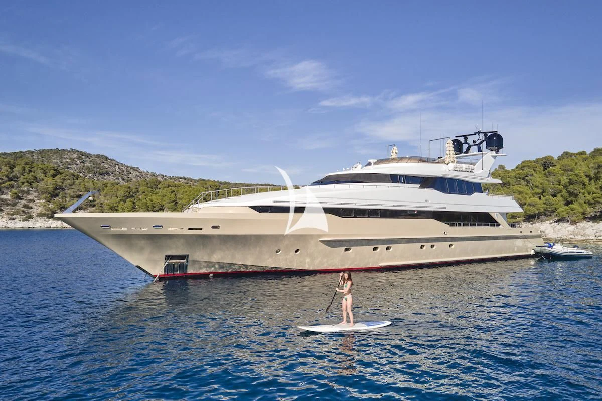 a person on a surfboard in front of a large boat aboard PROMETHEUS I Yacht for Charter