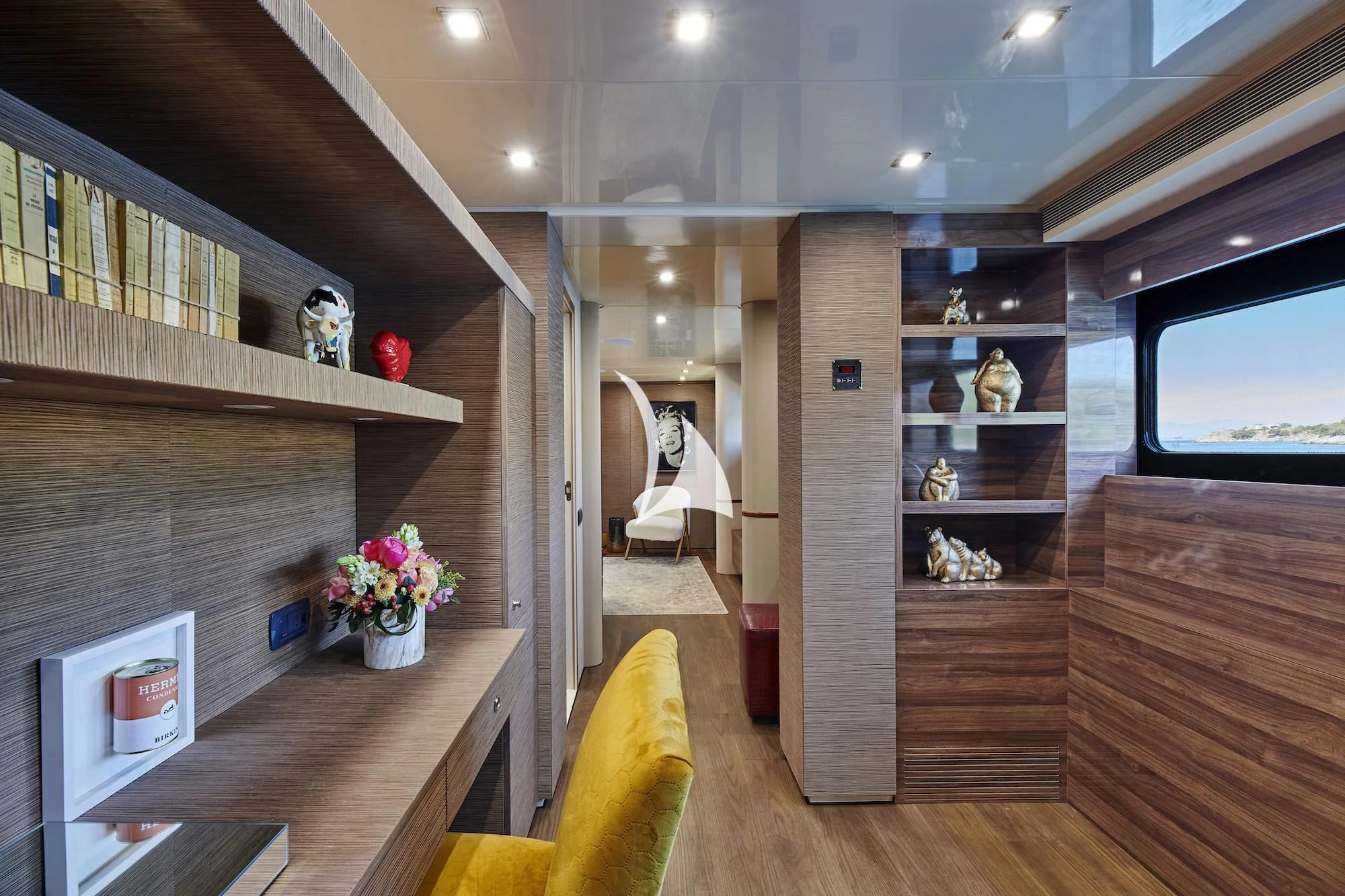 a room with a wood floor and a shelf with objects on it aboard PROMETHEUS I Yacht for Charter
