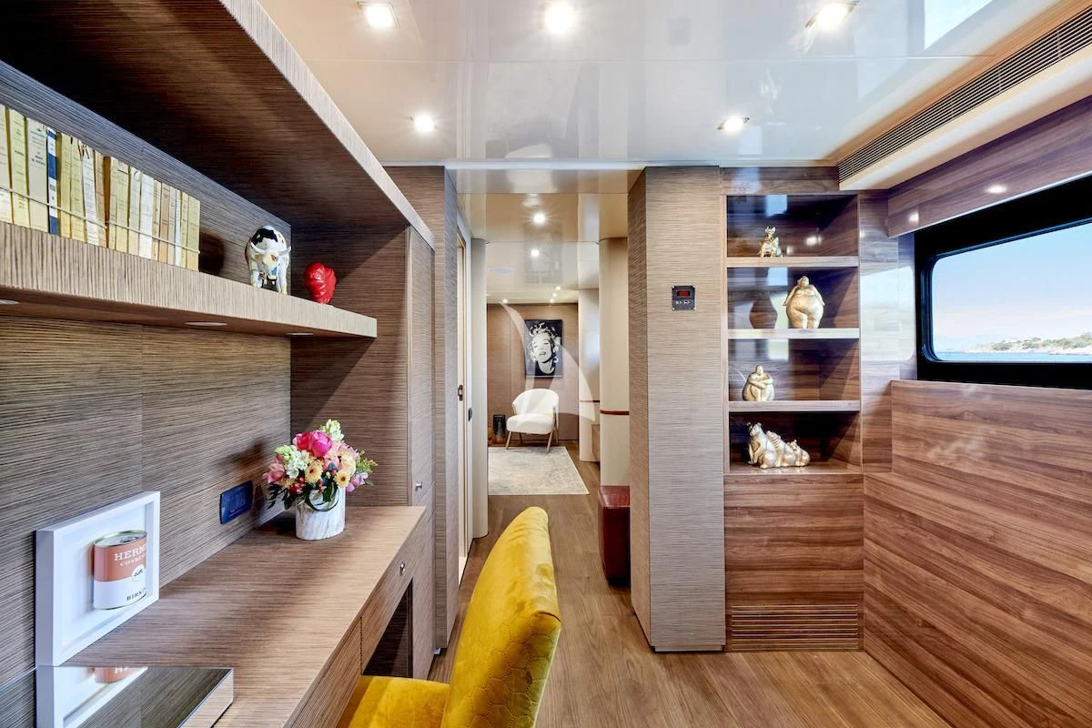 a room with a wood floor and shelves with objects on it aboard PROMETHEUS I Yacht for Charter