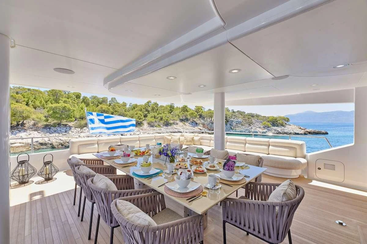 a table set for a meal on a deck overlooking the ocean aboard PROMETHEUS I Yacht for Charter