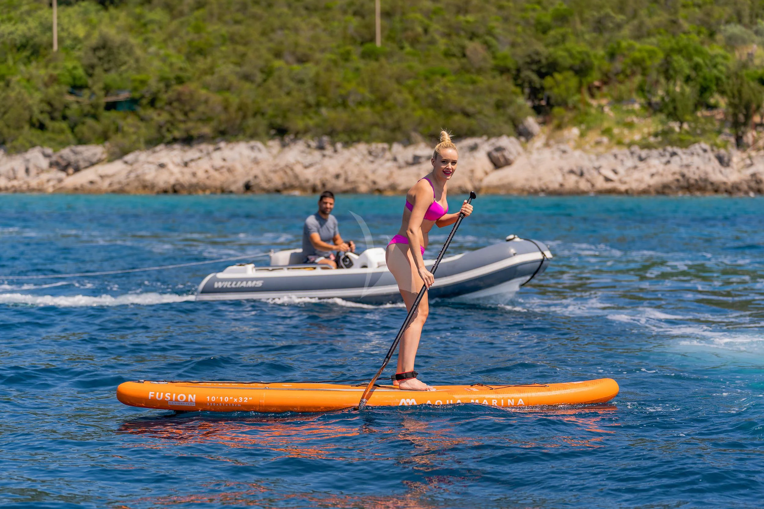a woman and a man on a paddle board in the water aboard VALENTINA II Yacht for Sale