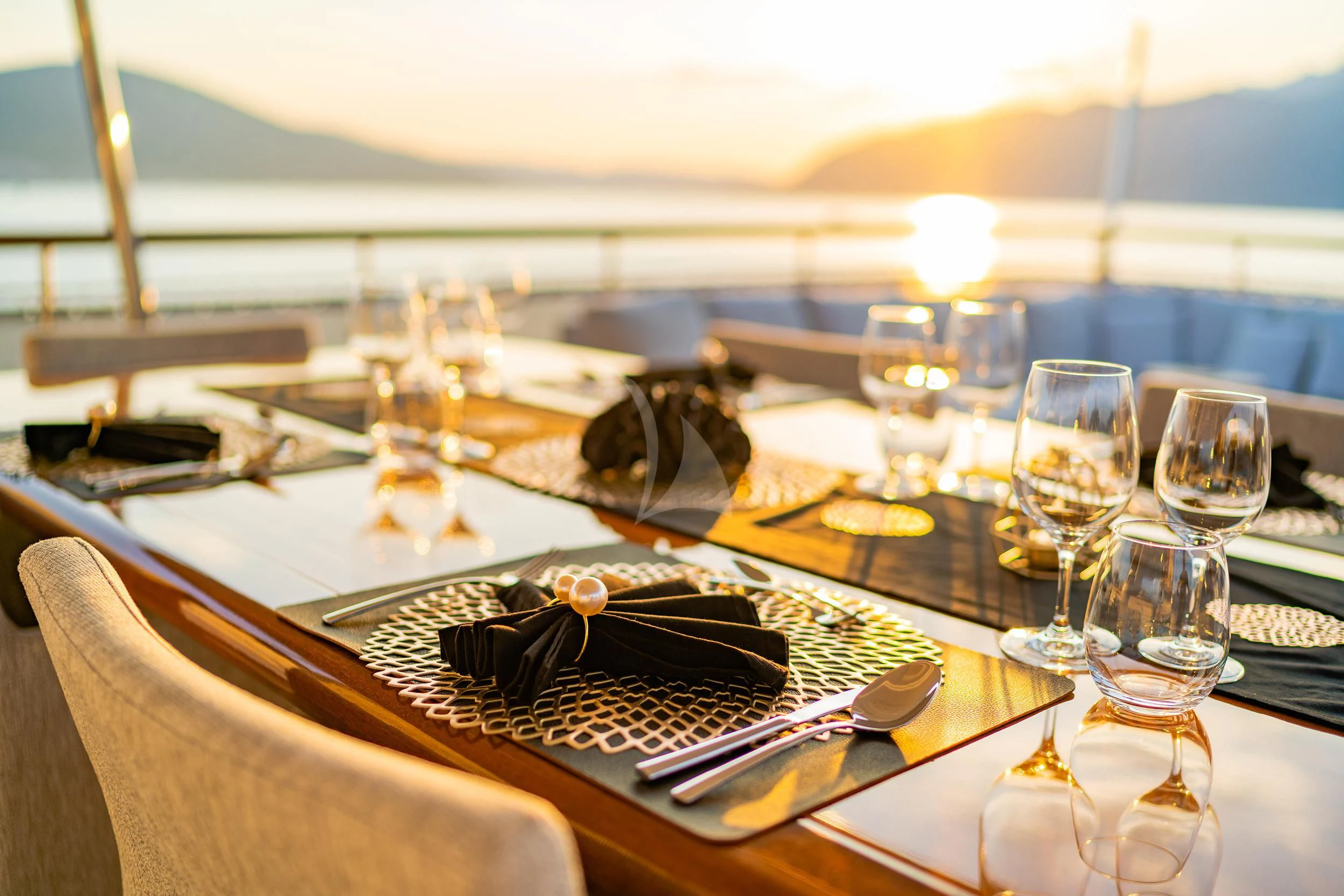 a table with a plate of food and glasses on it aboard VALENTINA II Yacht for Sale