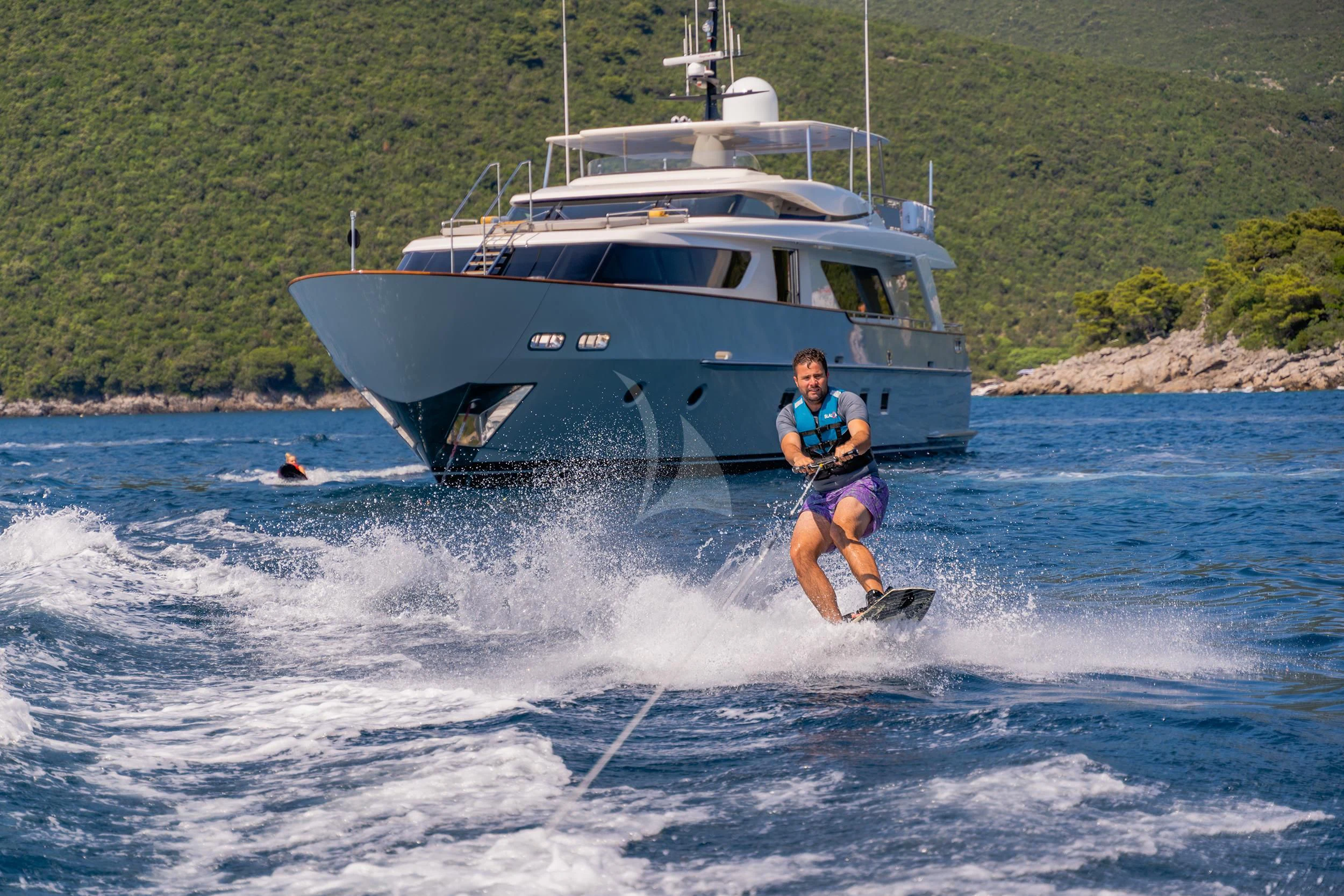 a man water skiing in front of a boat aboard VALENTINA II Yacht for Sale