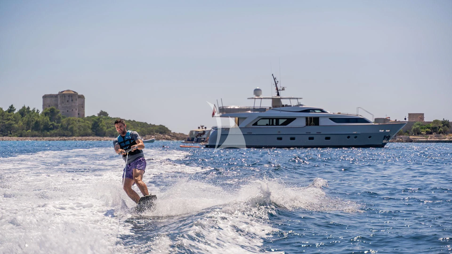 a man water skiing in front of a boat aboard VALENTINA II Yacht for Sale