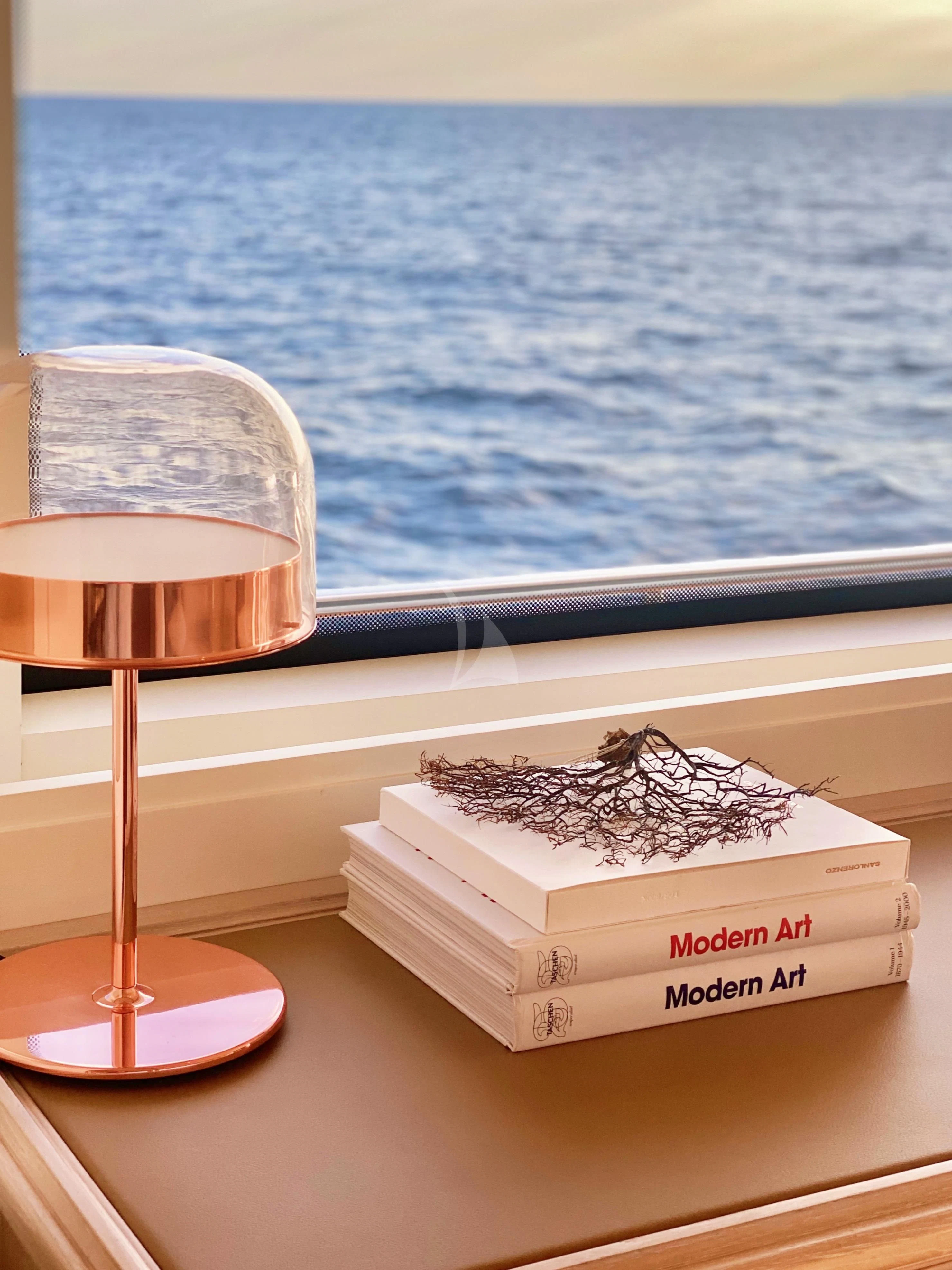 a lamp and a box on a table by the water aboard VALENTINA II Yacht for Sale