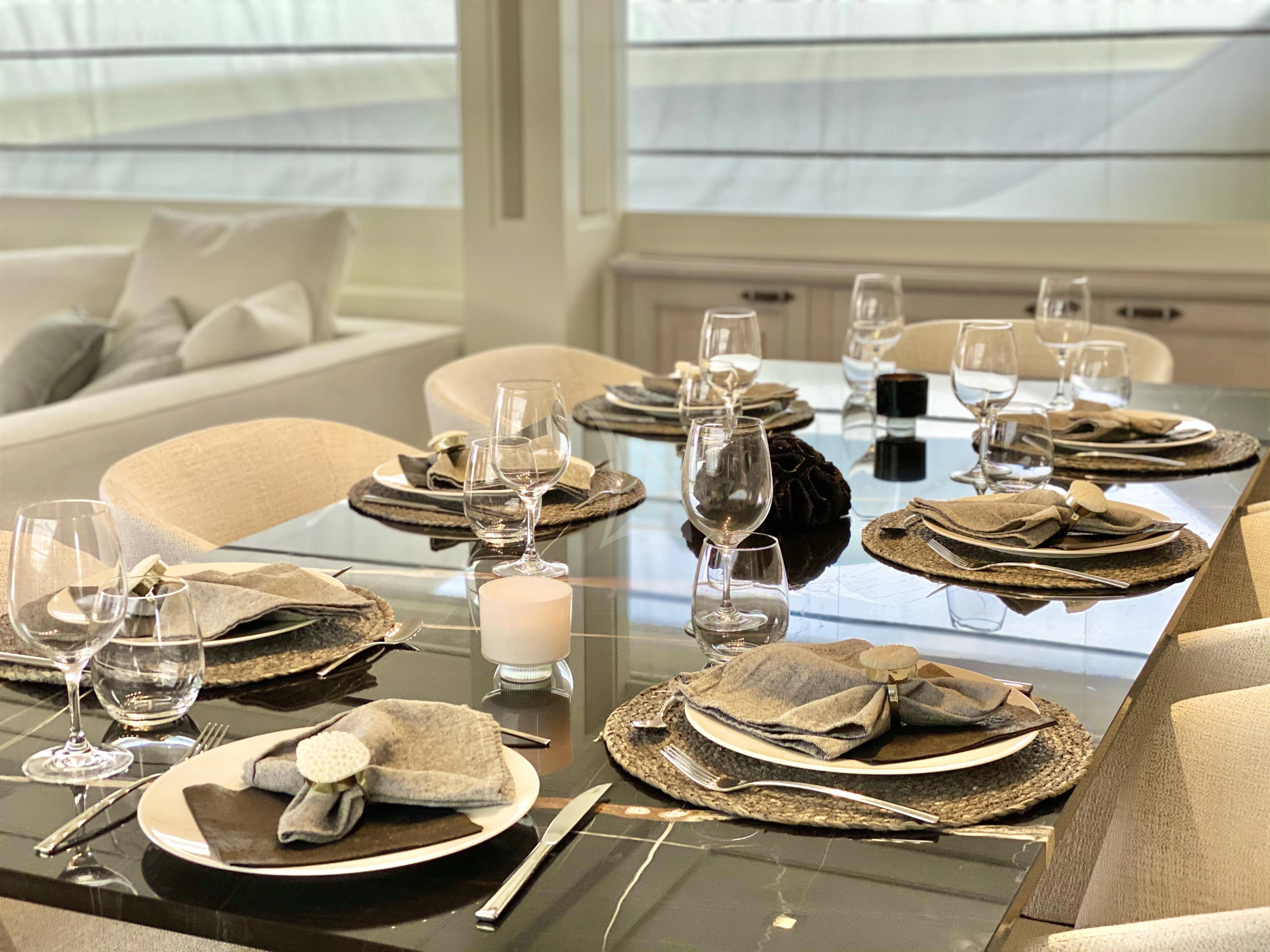 a table with plates and glasses aboard VALENTINA II Yacht for Sale