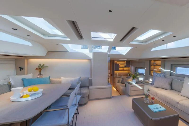 a living room with a table and couches aboard LIBERTY SQUARED Yacht for Sale