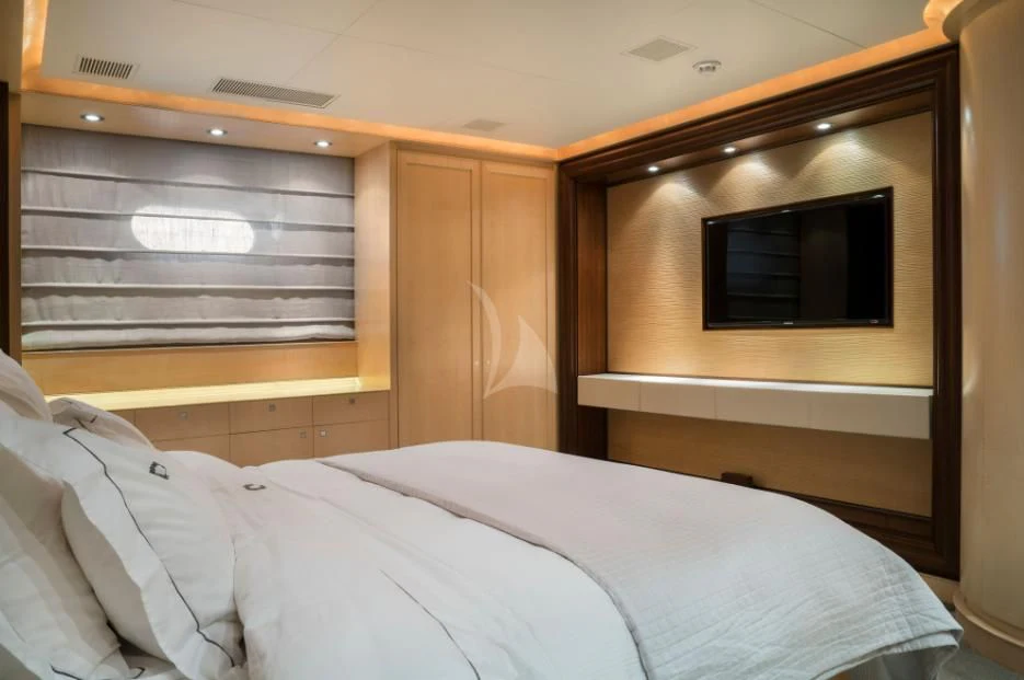 a bed with a television on the wall aboard VICTORIA A Yacht for Charter