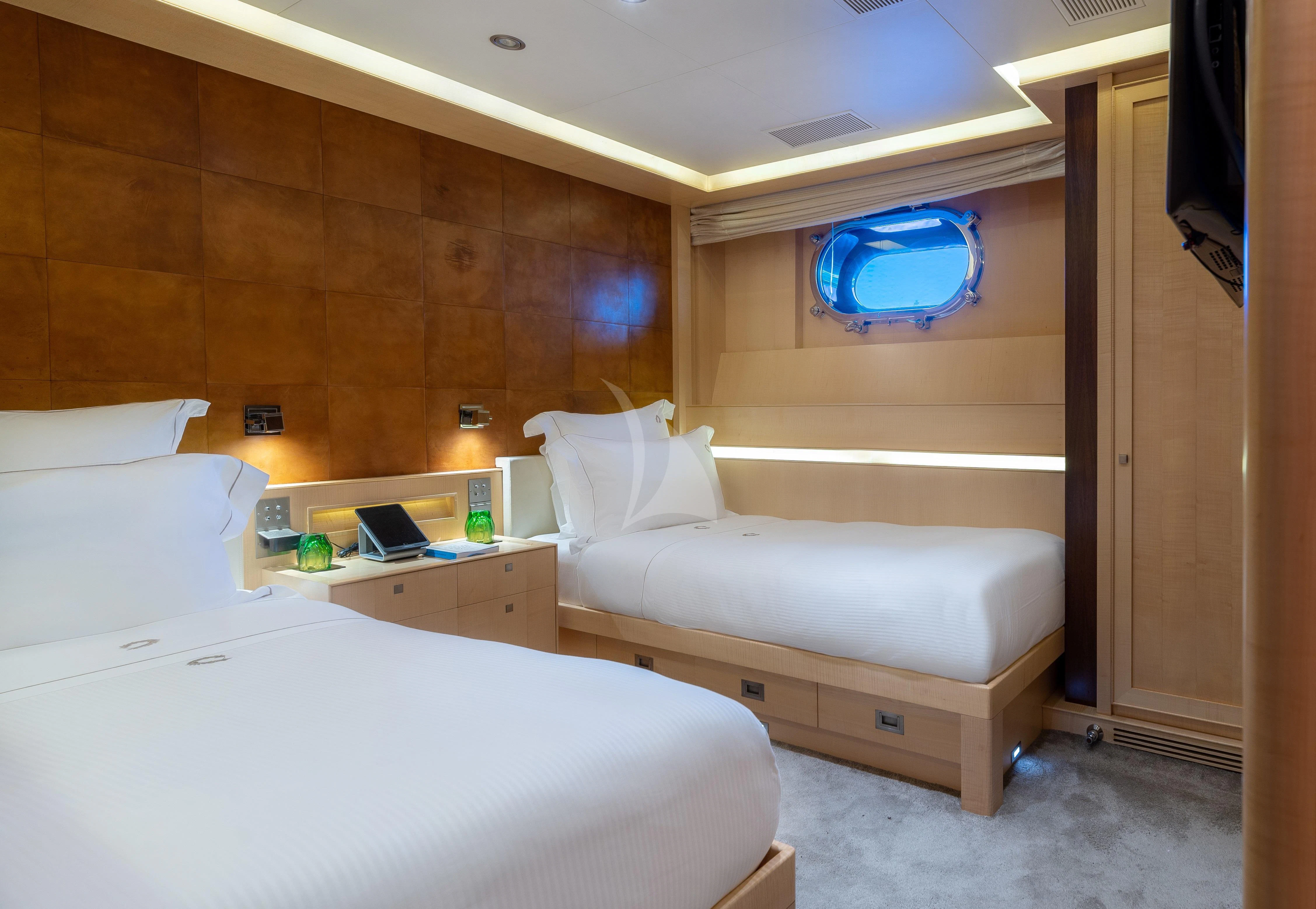 a room with beds and a desk aboard VICTORIA A Yacht for Charter