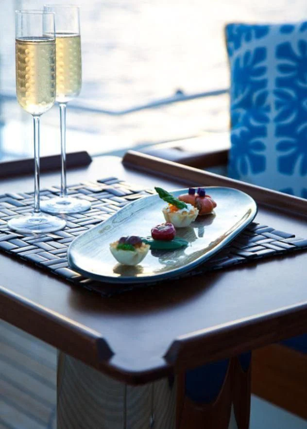 a plate of food and wine aboard VICTORIA A Yacht for Charter