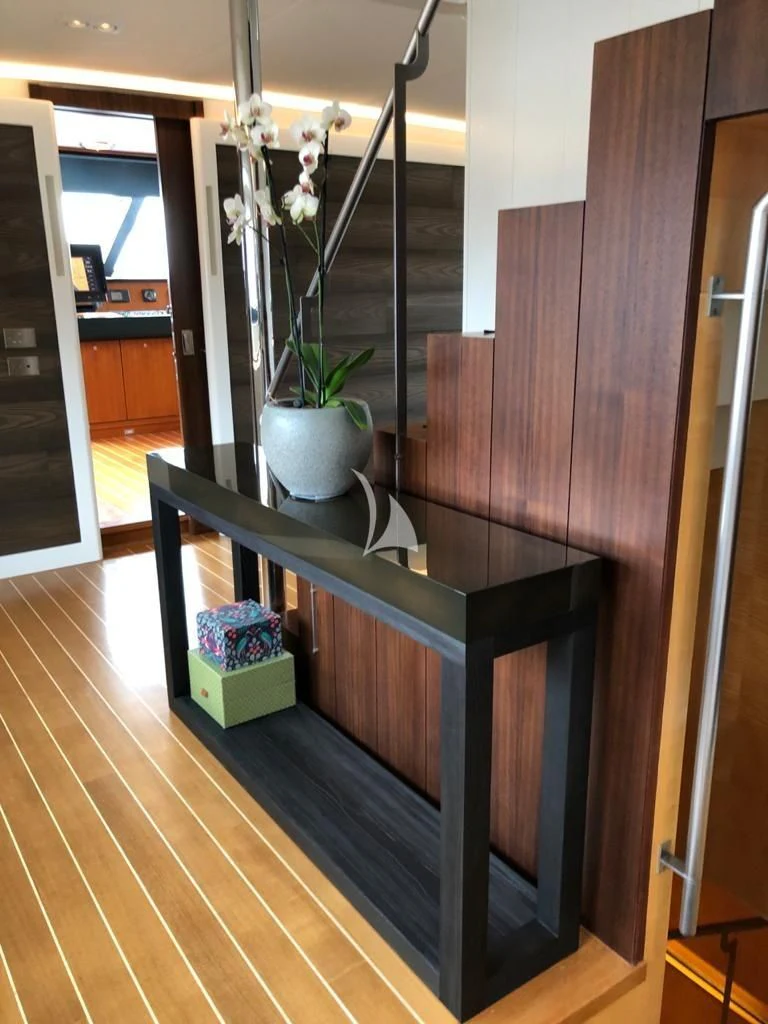 a wood shelf with a plant in a room with a wood floor aboard VICTORIA A Yacht for Charter