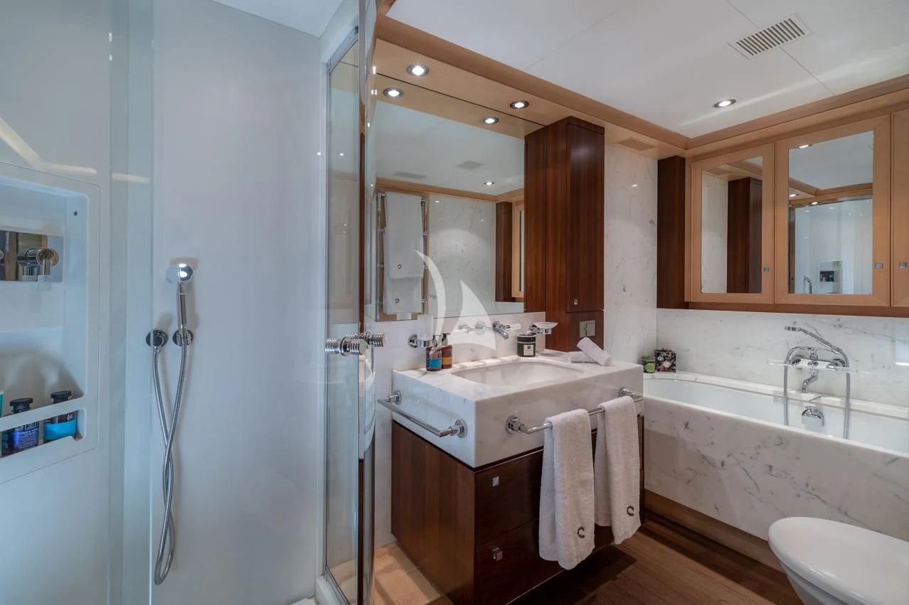 a bathroom with a tub sink and cabinets aboard VICTORIA A Yacht for Charter