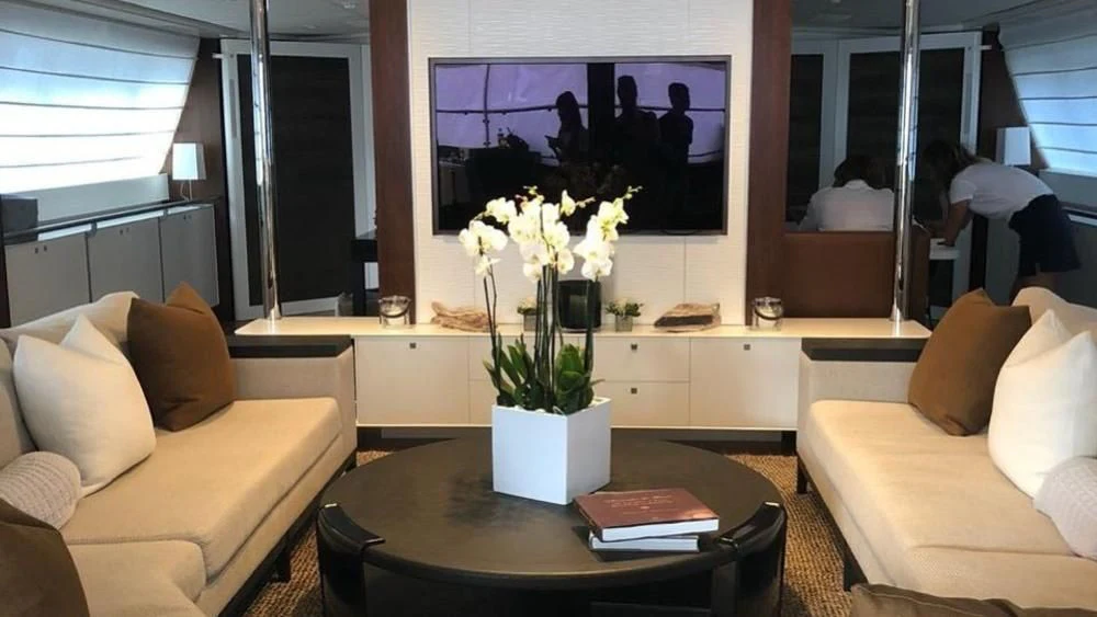 a living room with a table and couches aboard VICTORIA A Yacht for Charter