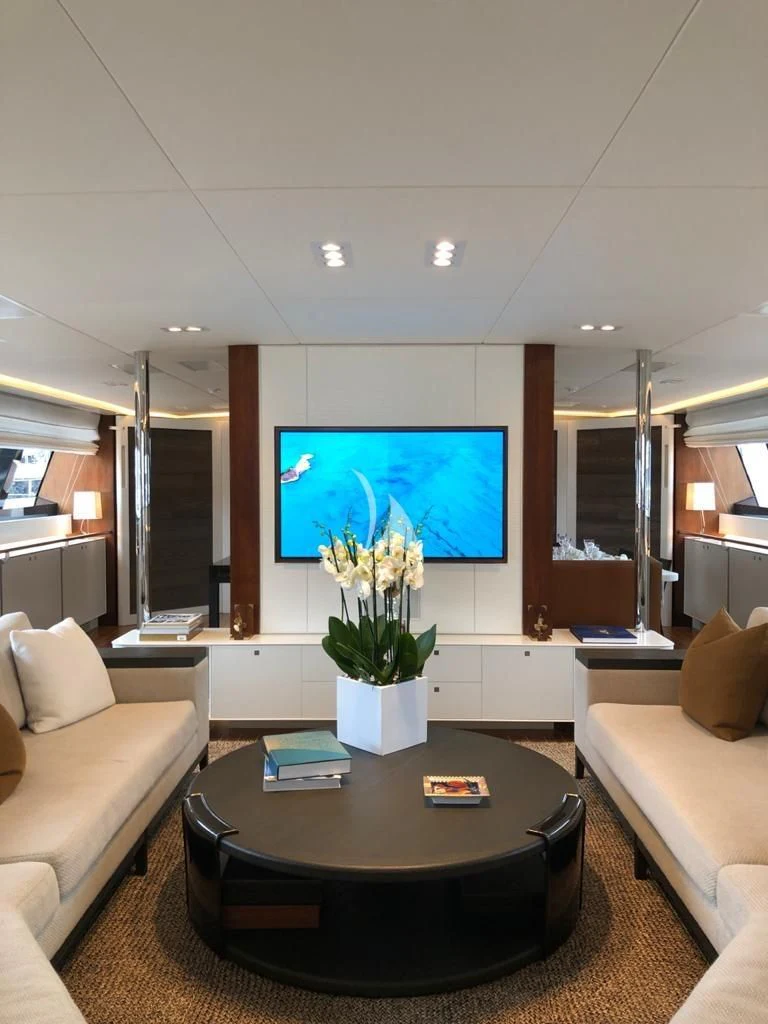 a living room with a table and couches aboard VICTORIA A Yacht for Charter