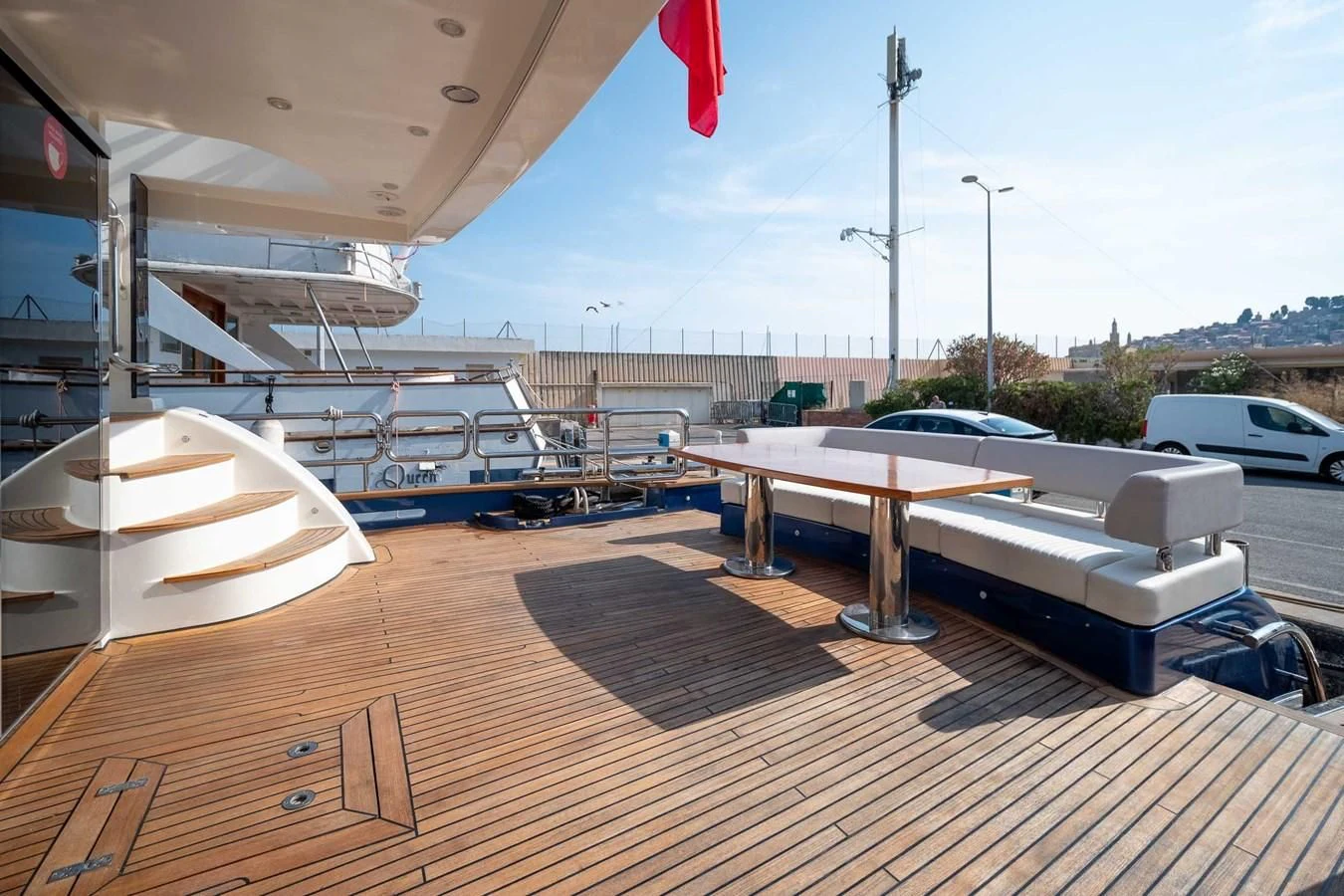 a deck with a boat and a flag on it aboard CHARISMA II Yacht for Sale