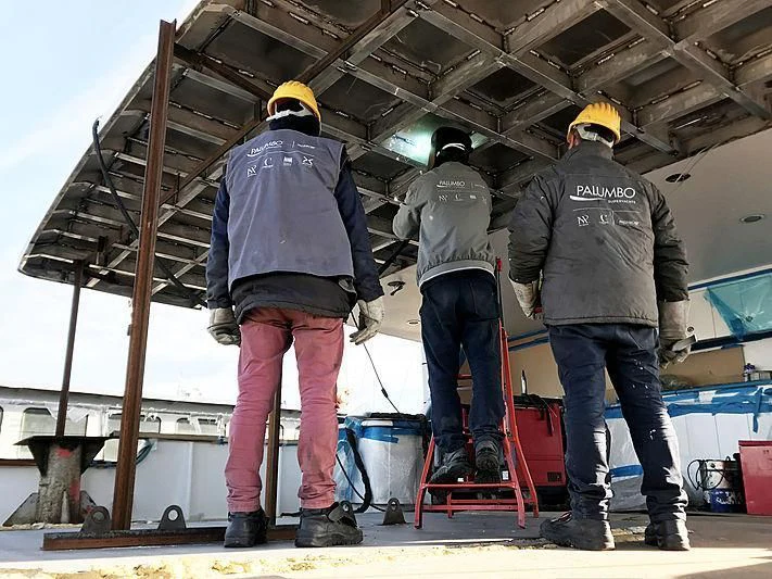 a group of men wearing hard hats aboard COMMITMENT Yacht for Sale