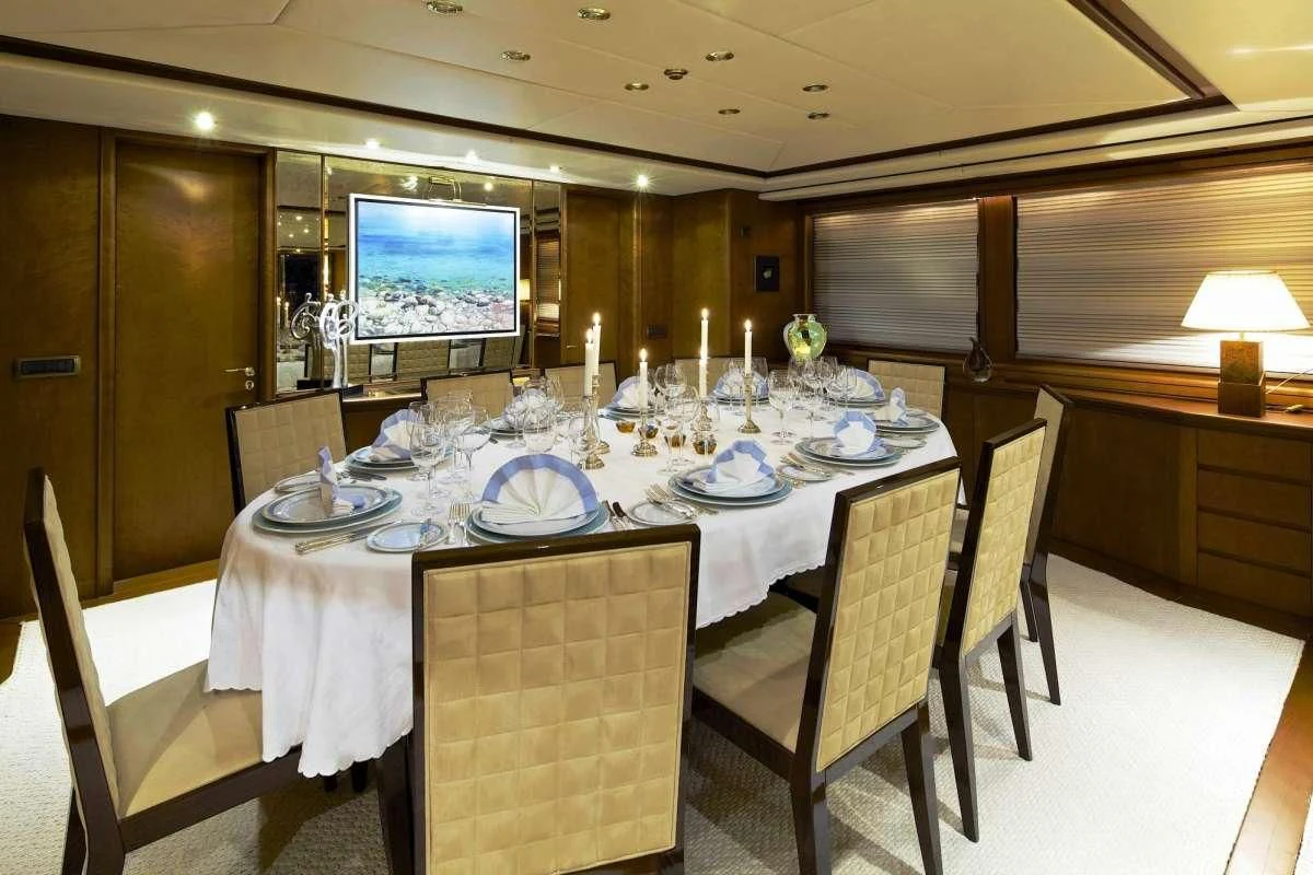 a dining room with a table set for a dinner aboard IDYLLE Yacht for Sale