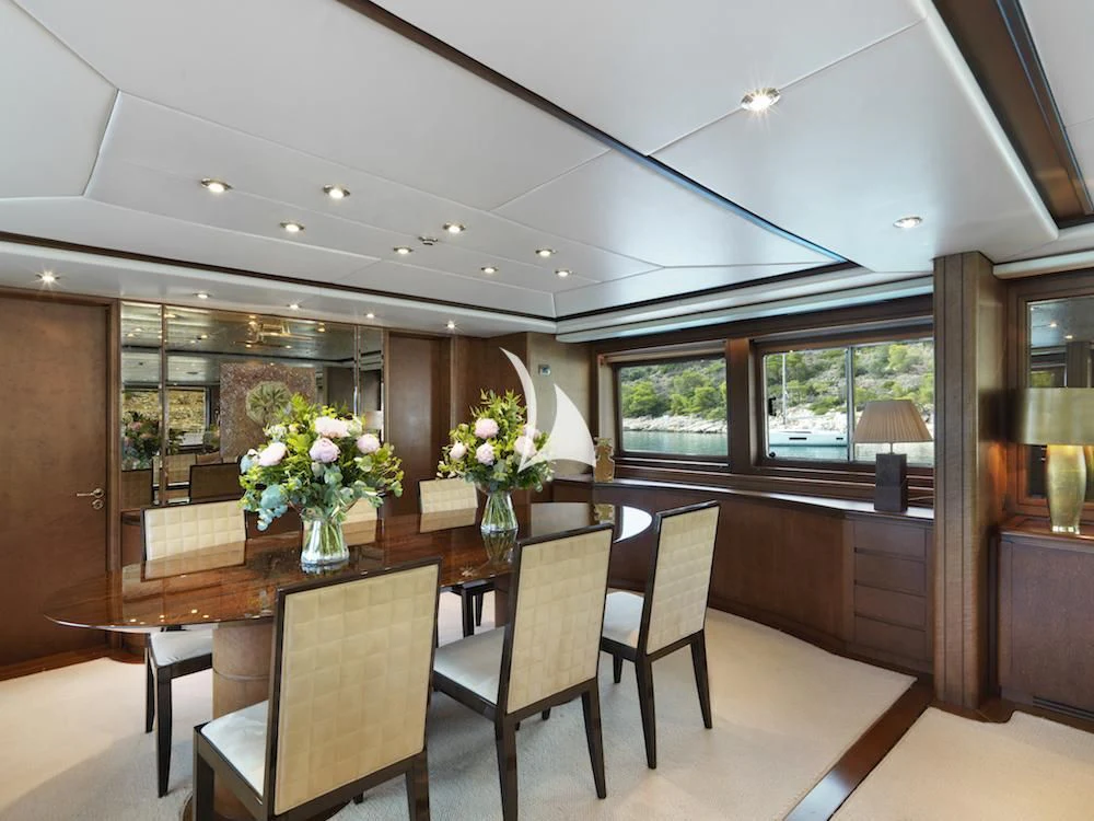 a large dining table in a room aboard IDYLLE Yacht for Sale