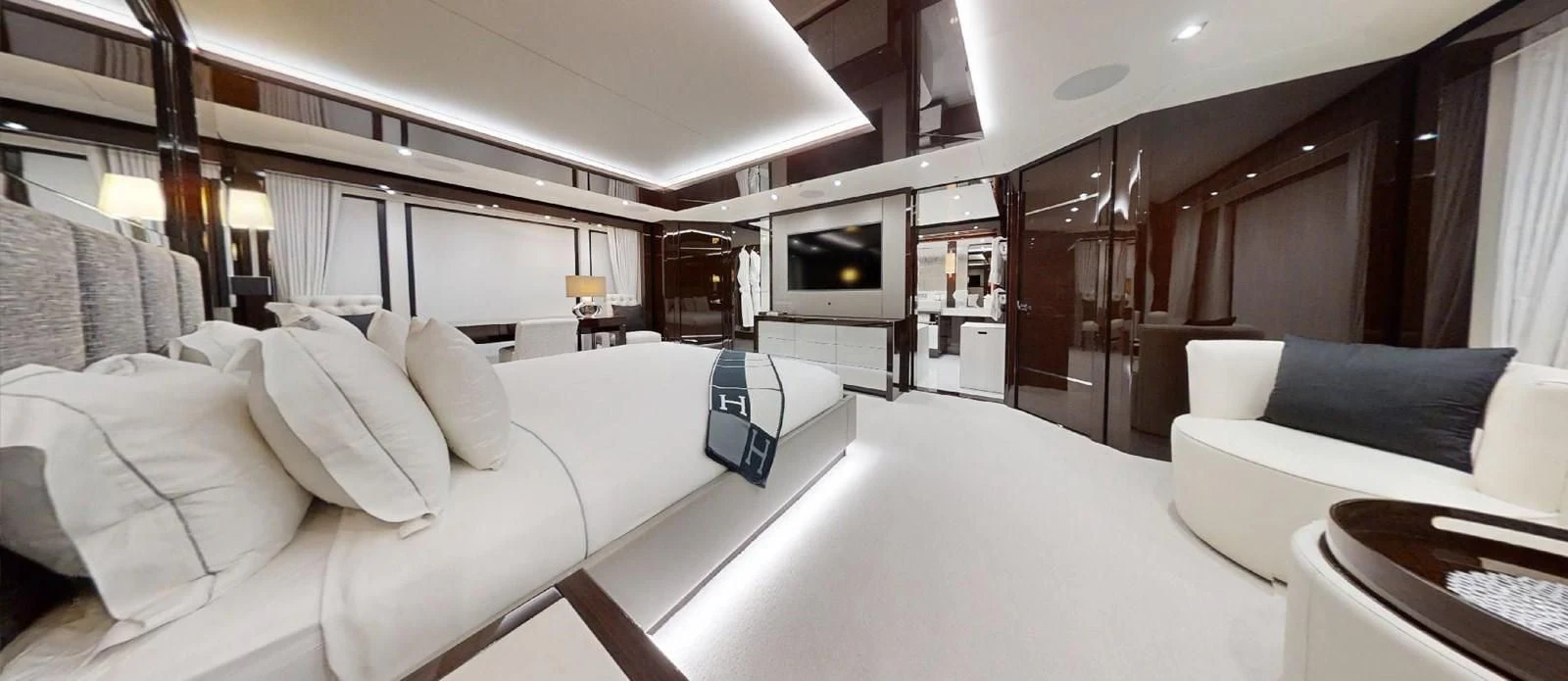 a room with a bed and a television aboard NOAH Yacht for Charter
