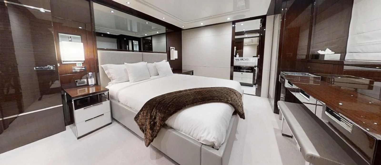 a room with a bed and a desk aboard NOAH Yacht for Charter