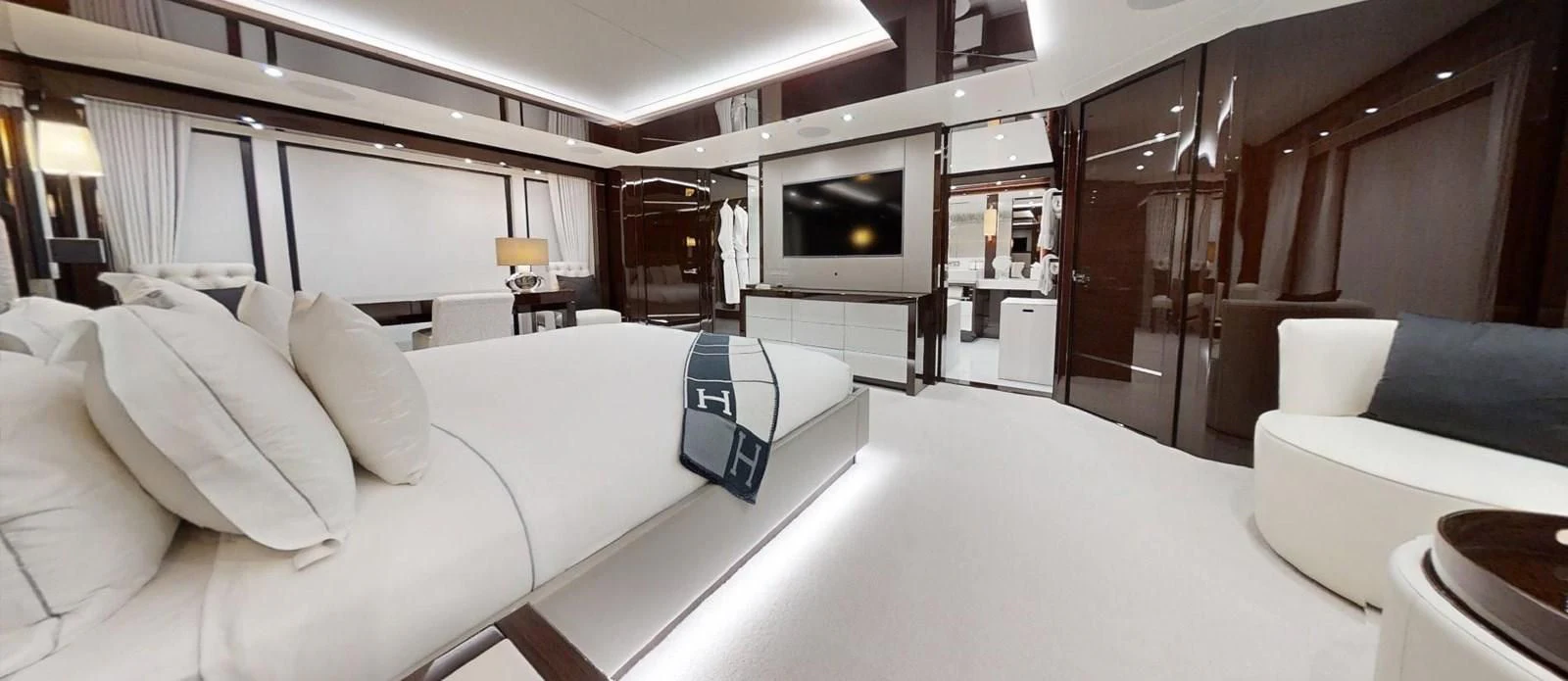 a room with a bed and a television aboard NOAH Yacht for Charter