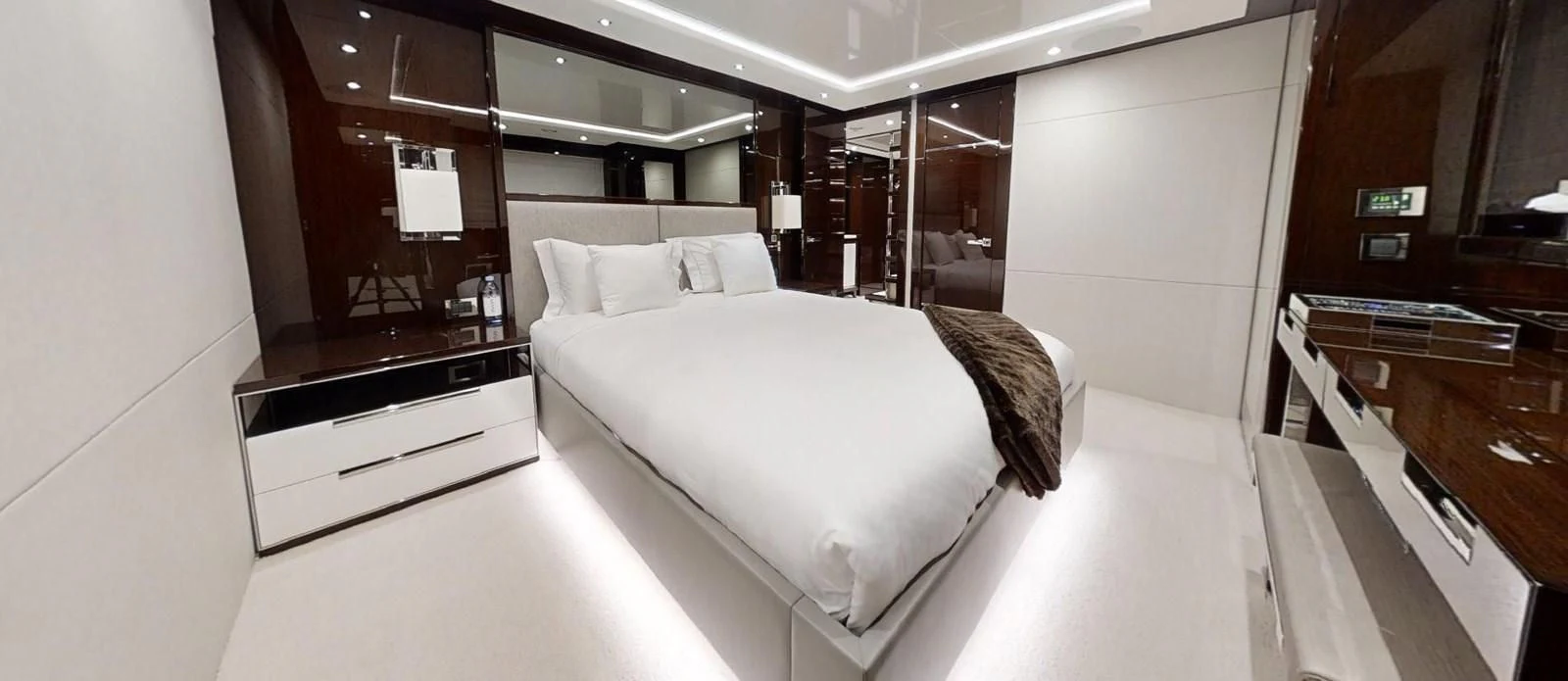 a room with a bed and desk aboard NOAH Yacht for Charter