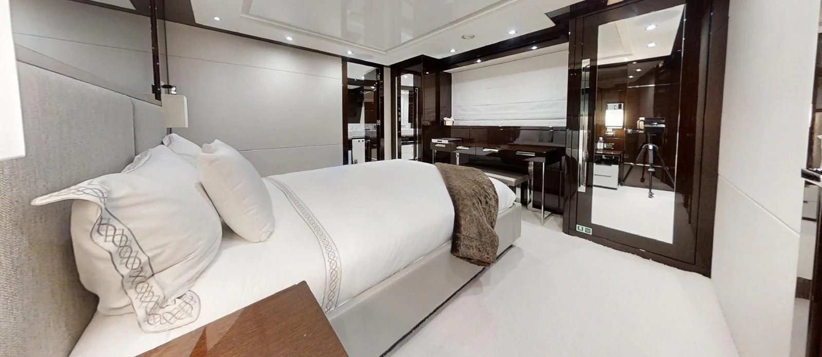 a room with a bed and a desk aboard NOAH Yacht for Charter