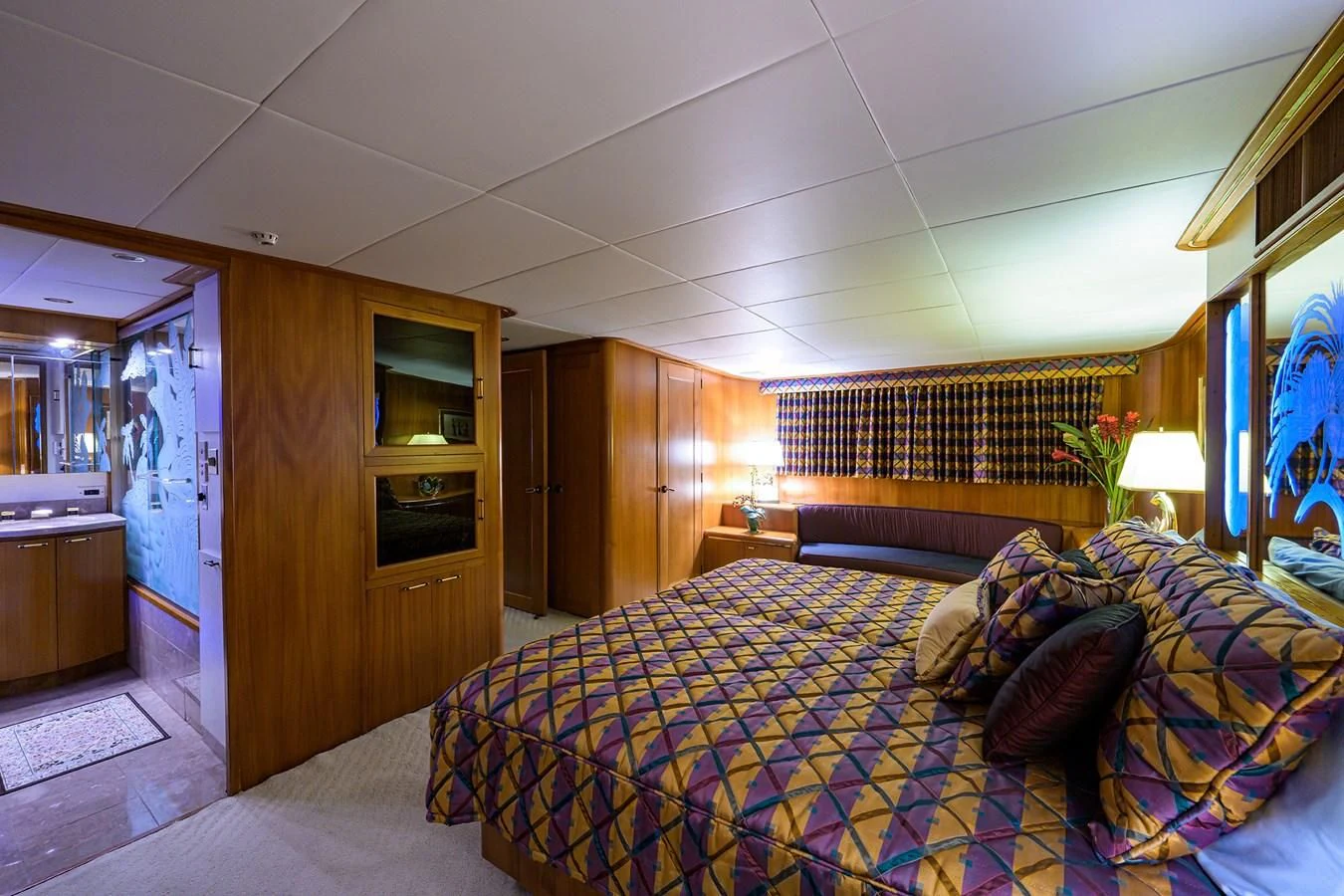 a bedroom with a bed and a wood cabinet aboard ARIES Yacht for Sale